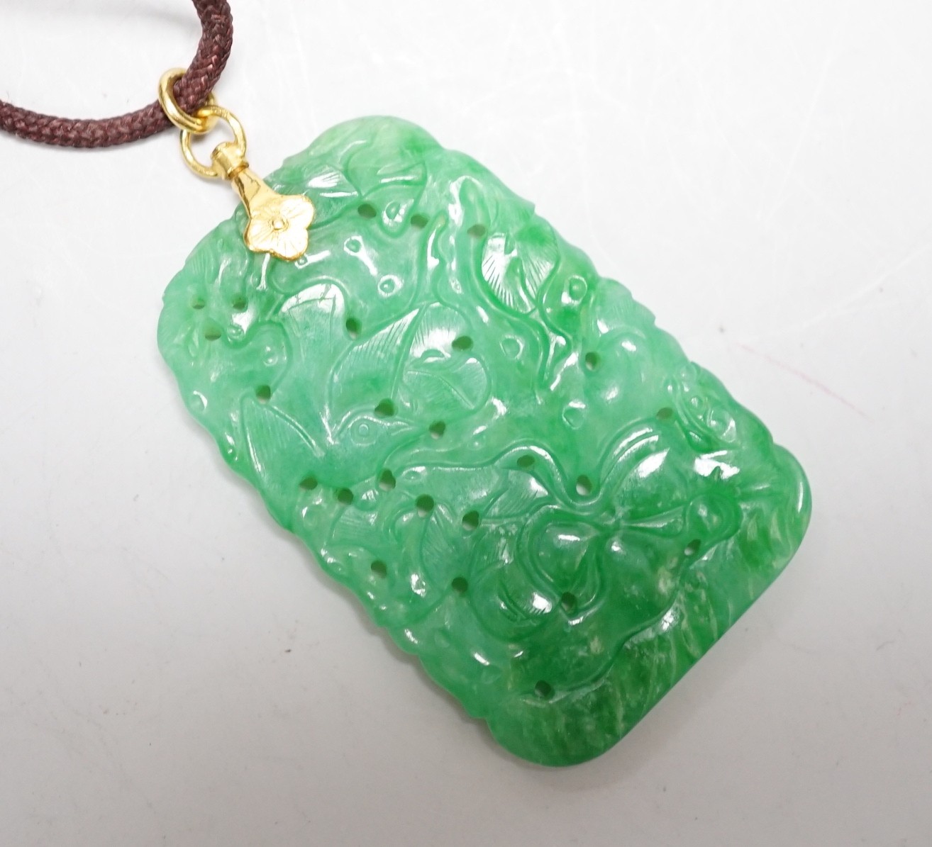 A carved Chinese jadeite pendant with pierced decoration. 5.5 x 3cm